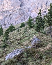 Stone cairn marking the meadow approach trail below Piccola Torre.