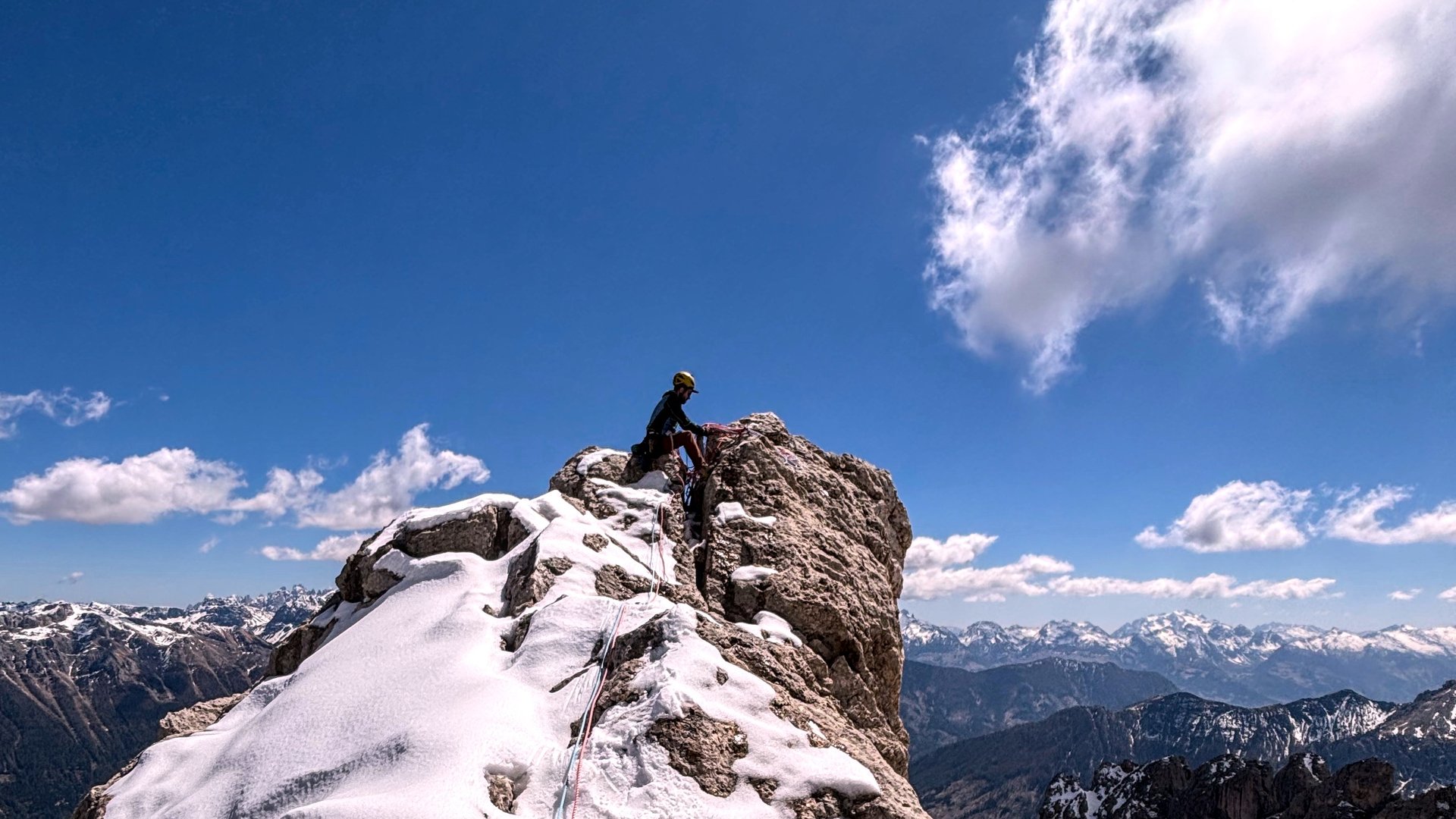A climber standing on the summit of Torre Finestra