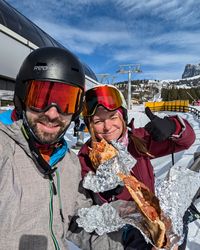 Wooden fence by the Tschein chairlift at Moser Alm serving as an impromptu lunch spot with leftover pizza.