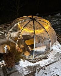 Transparent igloo bubble seating area on the terrace of Hotel Lake & River lit up at night.