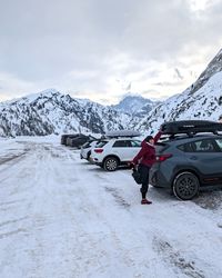 Daysi stretching beside the car at the Passo Fedaia parking lot before skiing Marmolada.
