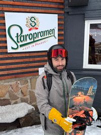 David posing in front of the Staropramen sign in front of the bar in Alpe Cermis, Cavalese.