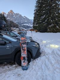 Snowboard by a car at the Panorama run parking in Buffaure, Pozza di Fassa