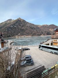 Free parking area by frozen Alleghe lake with mountain backdrop
