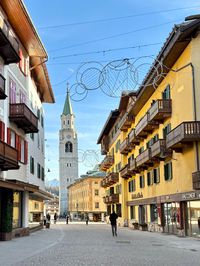 Historic church in downtown Cortina d'Ampezzo with bell tower and mountain backdrop