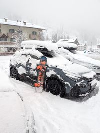 Snow-covered car parked in Alba in Val di Fassa