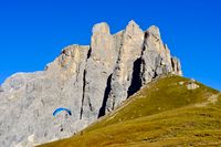 Paraglider launching from the meadows atop Passo Sella