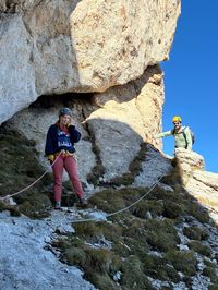 Two climbers roped together on the narrow descent trail below Roda di Vael.