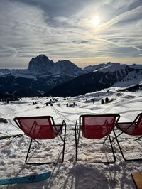 Troier Hütte lounge chairs overlooking Sassolungo across the valley in Val Gardena, Dolomites.
