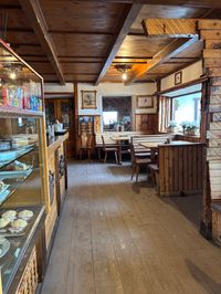 Cozy wooden interior with tables and seating at Rifugio Pomedes mountain hut, Tofana Olympic slope summit, Cortina d'Ampezzo