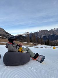 Snowboarder preparing on wide blue beginner slopes near Olimpia chairlift in Tofana ski area, Cortina d'Ampezzo