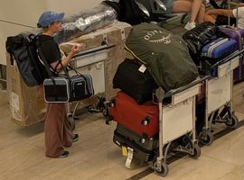 Two airport carts fully loaded with the moving bags