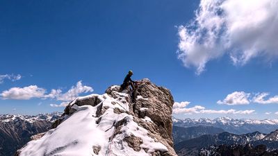A climber standing on the summit of Torre Finestra