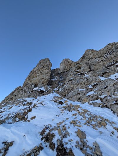 Hiker scouting the west-side summit approach on Monte Cornetto.