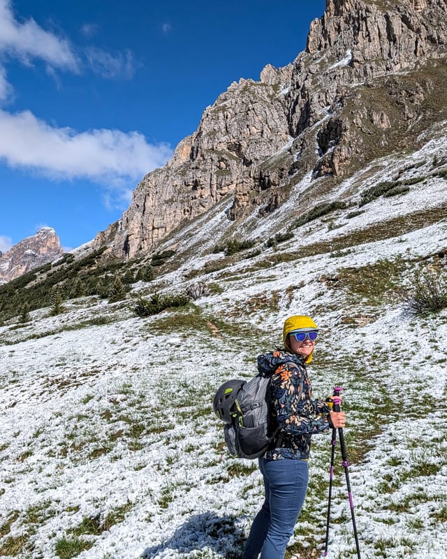 Hiker on the meadow approach trail below Pilastro Moni.