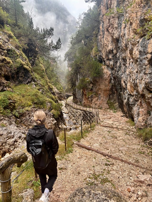 Rain-soaked trail along an alpine stream returning to Tschafon Hut