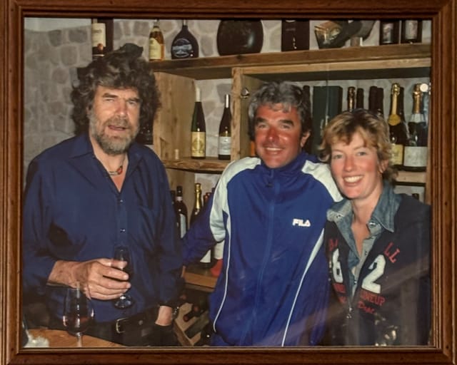 Framed photo of Reinhold Messner with two visitors inside Rifugio Roda di Vael.